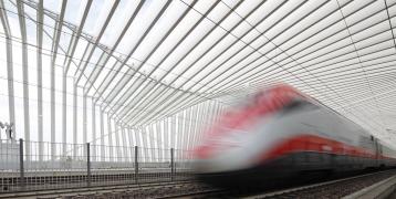 Train driving past in station at high speed